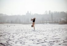 겨을철 체중 조절, 운동과 올바른 식습관의 중요성 woman in black tank top and brown shorts jumping on snow covered ground during daytime