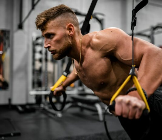 전문가들이 추천하는 어깨 건강을 위한 운동 topless man in black pants holding black and yellow exercise equipment