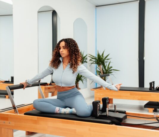 3~40대 여성들의 운동: 필라테스 a woman sitting on a piyor in a room