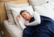 수면의 질을 높이는 5가지 실질적인 생활 습관 a woman sleeping on a bed with a blue blanket