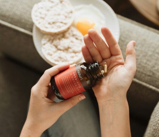 영양제, 어떻게 똑똑하게 챙길까? 한국인의 일상을 위한 실천 팁 person holding red bottle