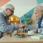 “노화의 시계를 늦춰라”… 젊은 층이 ‘슬로우 조깅’에 열광하는 이유 Two elderly men playing chess at a table.