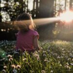 MZ세대가 앞장서는 ‘마음 챙김 명상’, 일상에 쉽게 녹이는 법 girl sitting on daisy flowerbed in forest