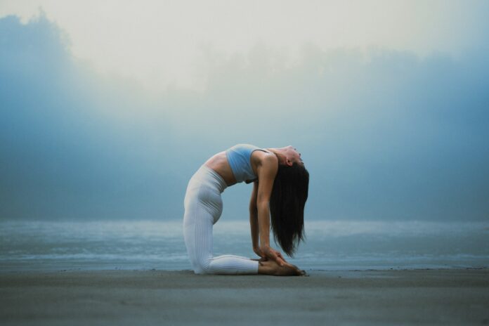 Photo by Jaspinder Singh A woman doing a yoga pose on the beach