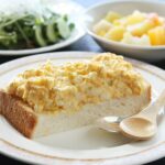 집밥의 부활, 바쁜 일상 속 슬기로운 건강 식사법 A white plate topped with a slice of cake next to a bowl of salad