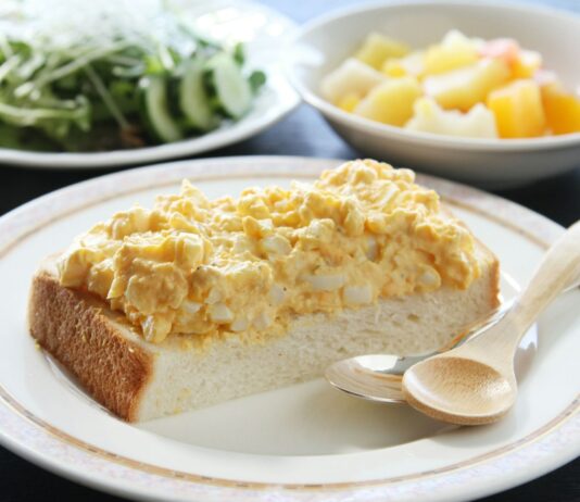 집밥의 부활, 바쁜 일상 속 슬기로운 건강 식사법 A white plate topped with a slice of cake next to a bowl of salad