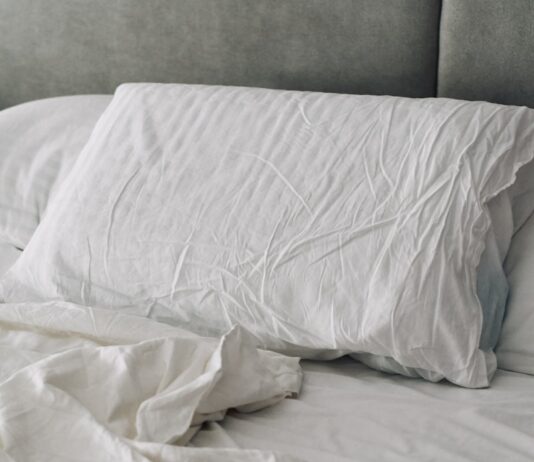 수면의 질을 높이는 생활 습관, 실천 가능한 작은 변화에서 시작 A rumpled white duvet and pillows on a bed.