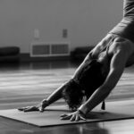 대체요법, 일상에 스며든 건강 습관…실천 루틴과 주의할 점은? woman in black tank top and black pants bending her body on floor
