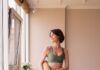 집에서 즐기는 필라테스, 바른 자세와 건강한 일상 만드는 열쇠 a woman in a green sports bra top and leggings holding a yoga mat