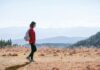 “걷기, 일상 속 작은 변화로 건강 지키기… 최신 워킹 트렌드와 실천법” a man with a backpack walking across a dry grass covered field